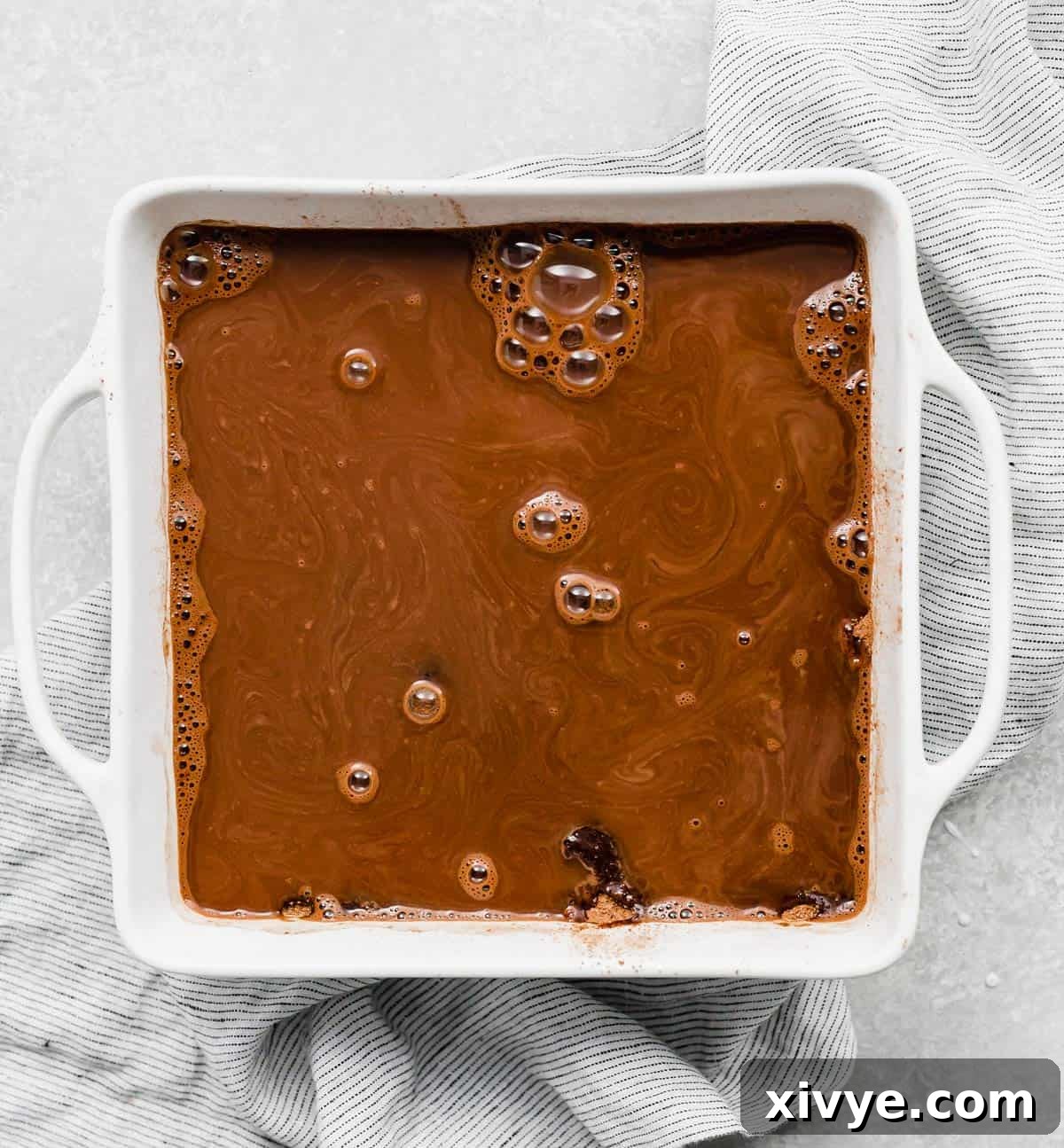 Molten Chocolate Dream 7 A square white pan with boiling water poured overtop a hot fudge cake batter.