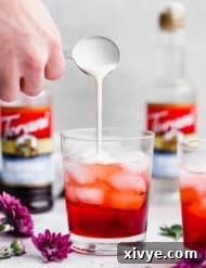 Heavy cream being poured into a glass cup, making Italian cream soda.