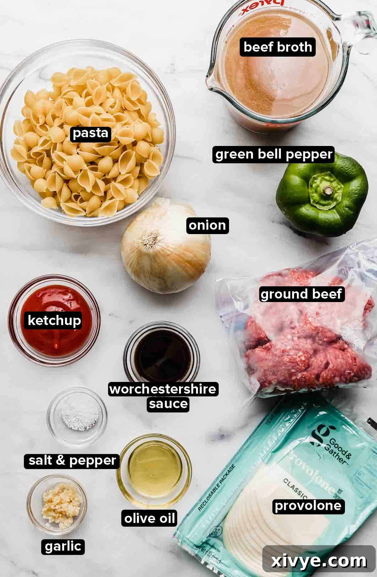 Creamy Instant Pot Philly Cheesesteak Pasta 3 Instant Pot Philly Cheesesteak Pasta ingredients, including ground beef, pasta, bell peppers, provolone cheese, and various seasonings, neatly arranged on a white marble background.