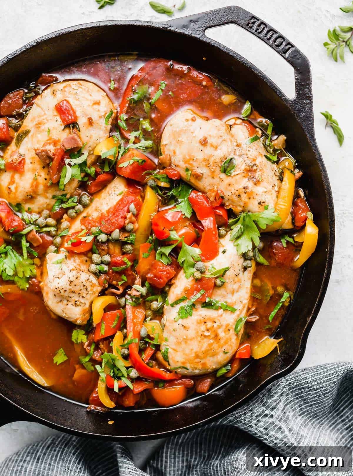 Imperial Chicken 2 Roman Chicken with capers and red peppers in a black skillet.