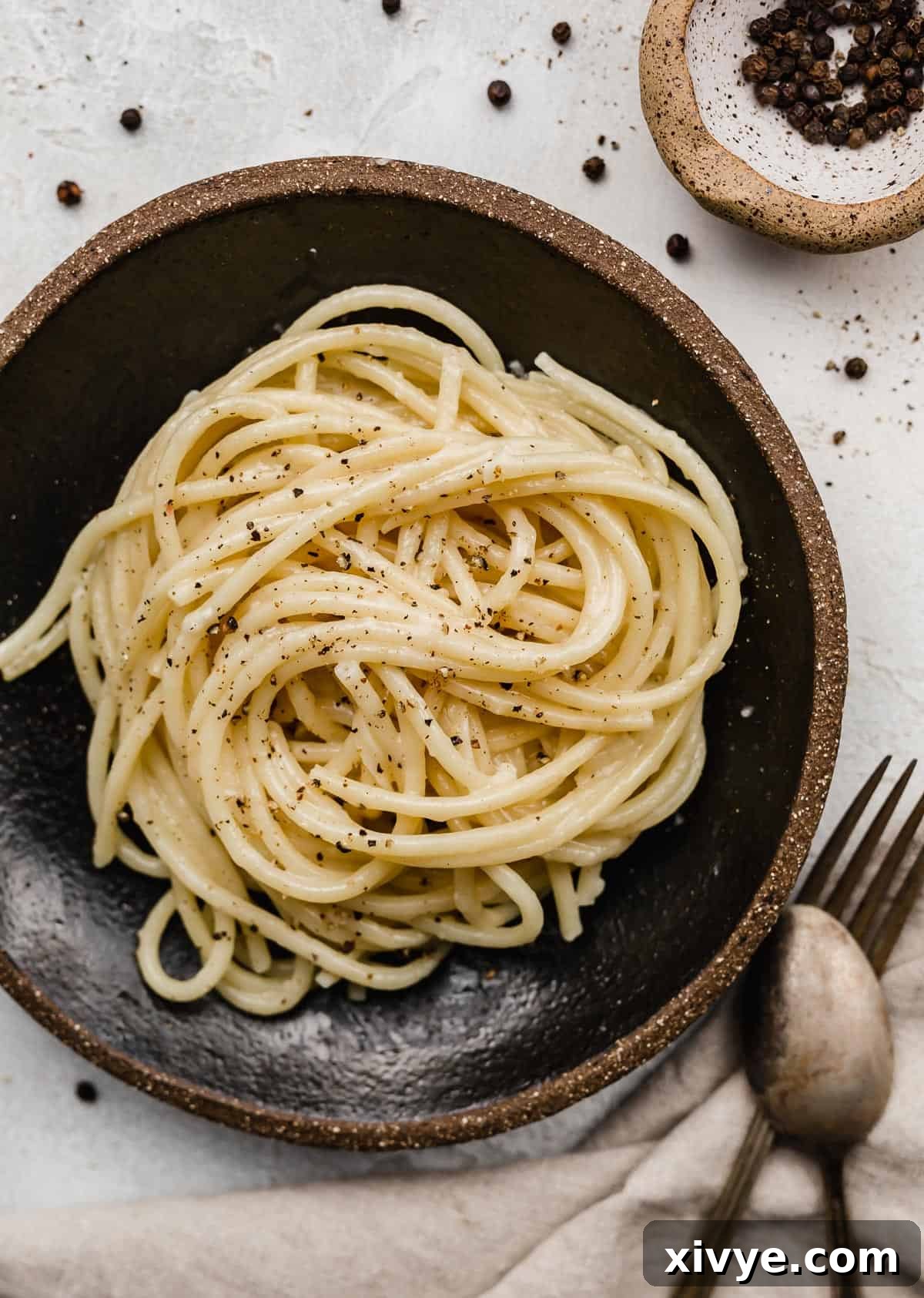 The Ultimate Bucatini Cacio e Pepe 2 Bucatini Cacio e Pepe noodles swirled in a black bowl.