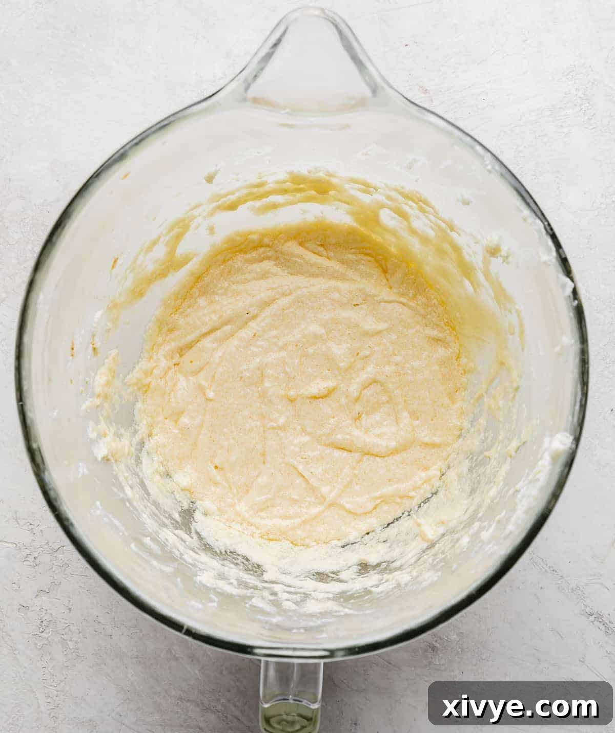 No Fail Sugar Cookies batter in a glass bowl on a gray background.