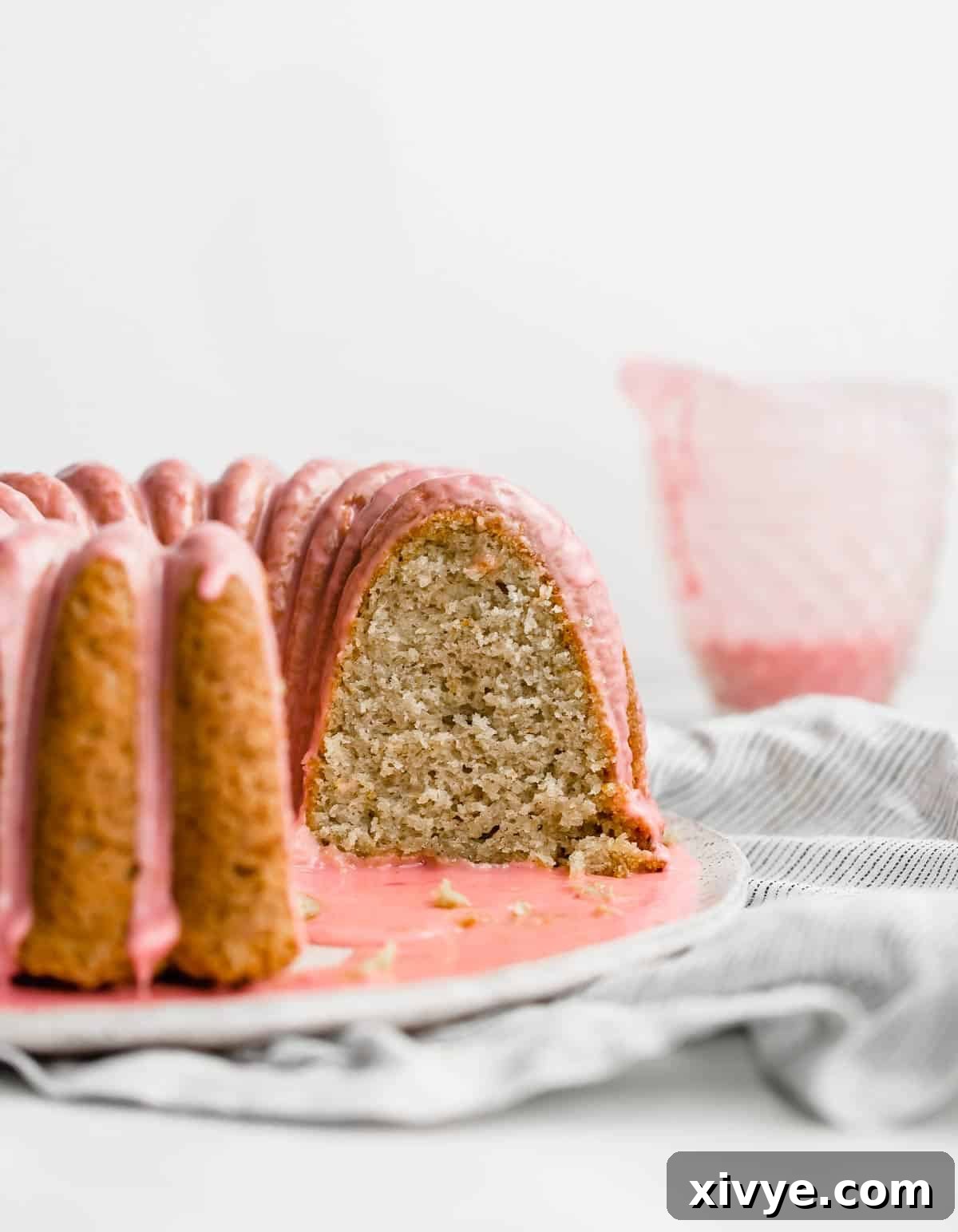 A slice of blood orange bundt cake with cardamom, showing its moist, soft interior and a hint of pink glaze.