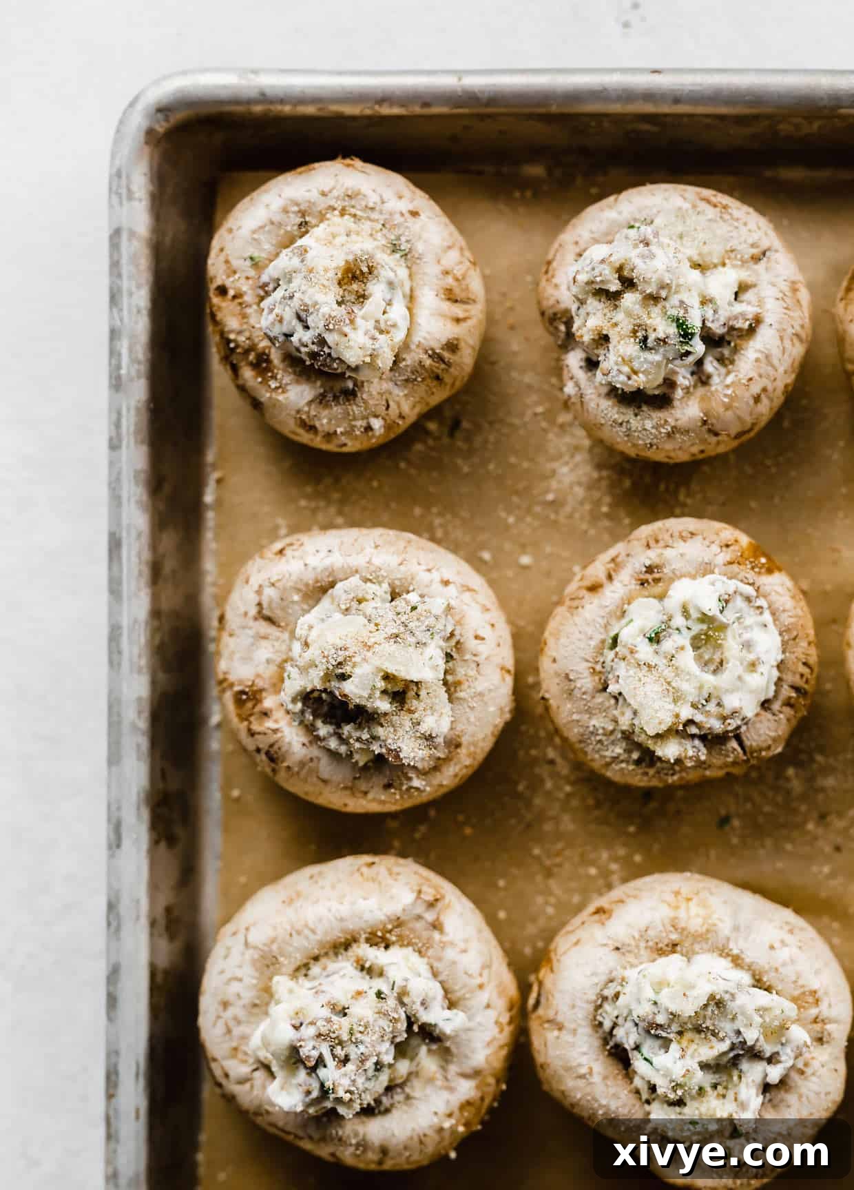 Zesty Italian Sausage Stuffed Mushrooms 6 Italian Sausage and cream cheese Stuffed Mushrooms, gill sides up on a baking sheet.