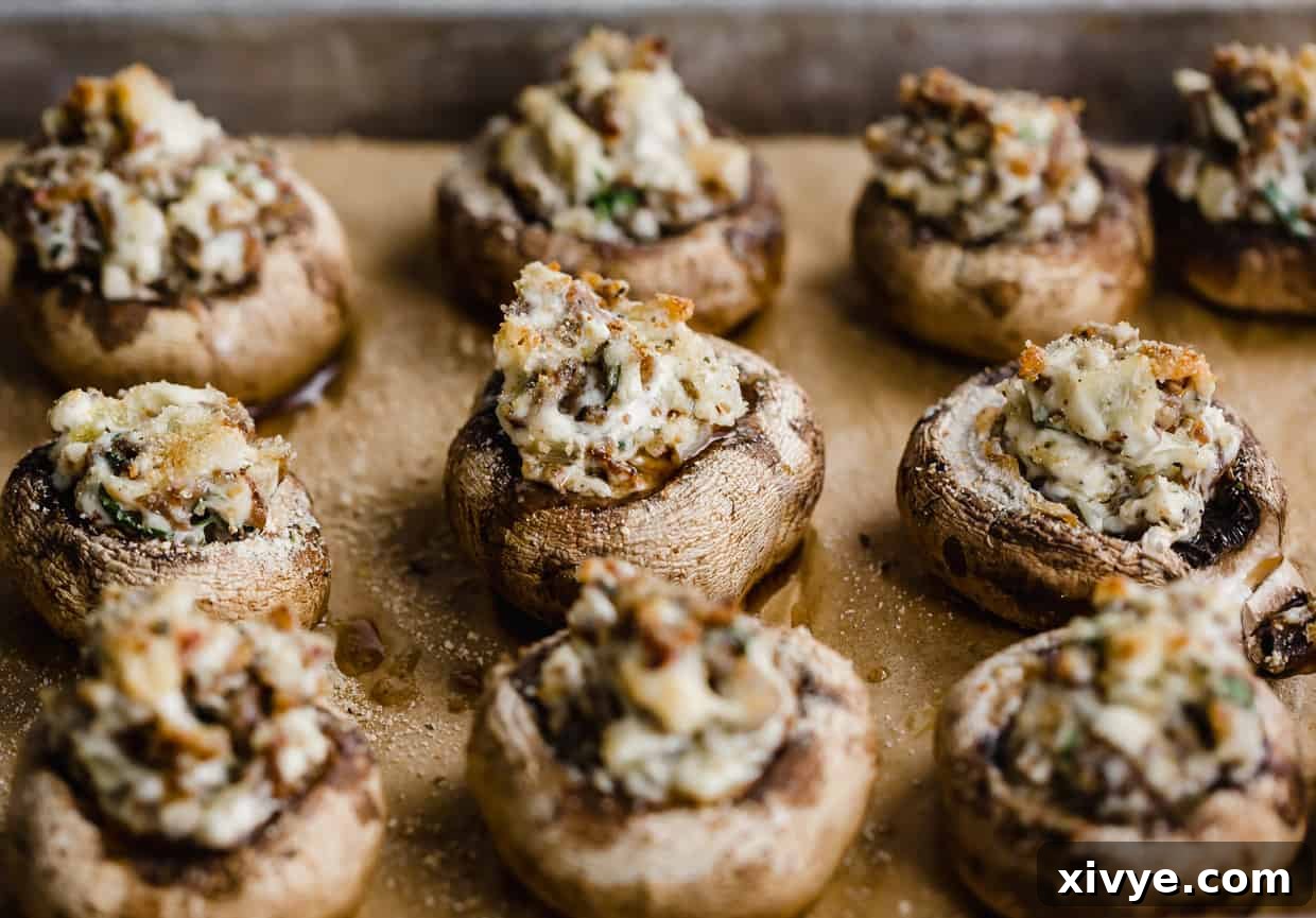Zesty Italian Sausage Stuffed Mushrooms 7 Italian Sausage Stuffed Mushrooms lined on a baking sheet.