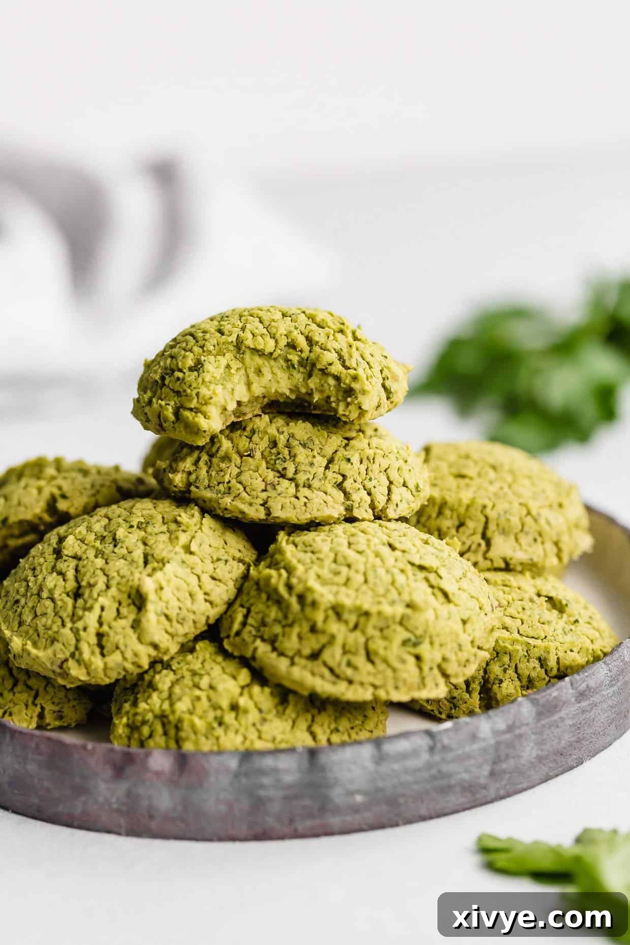 Baked Falafel on a black plate with the top falafel having a bite removed from it.