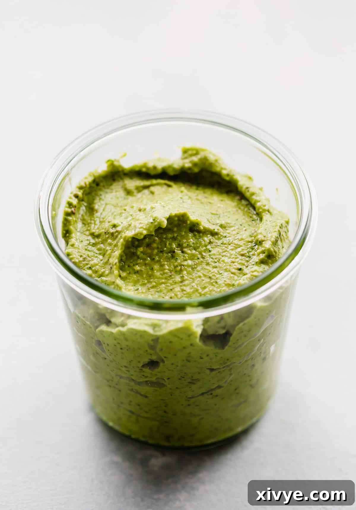 A glass jar filled with a thick Green Sauce Recipe in it.
