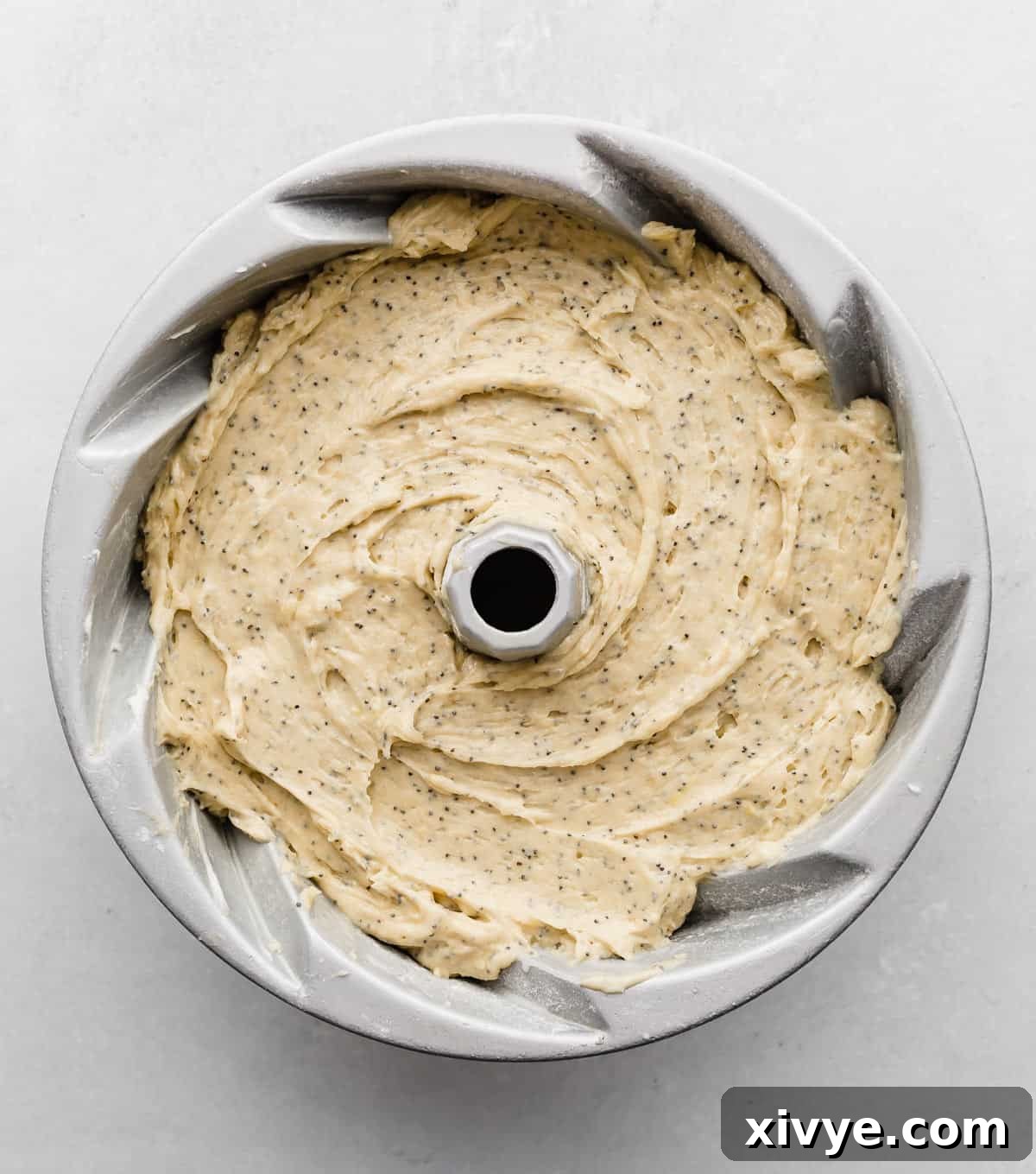 A Bundt Cake full of lemon poppy seed cake batter, smoothed and ready for the oven.