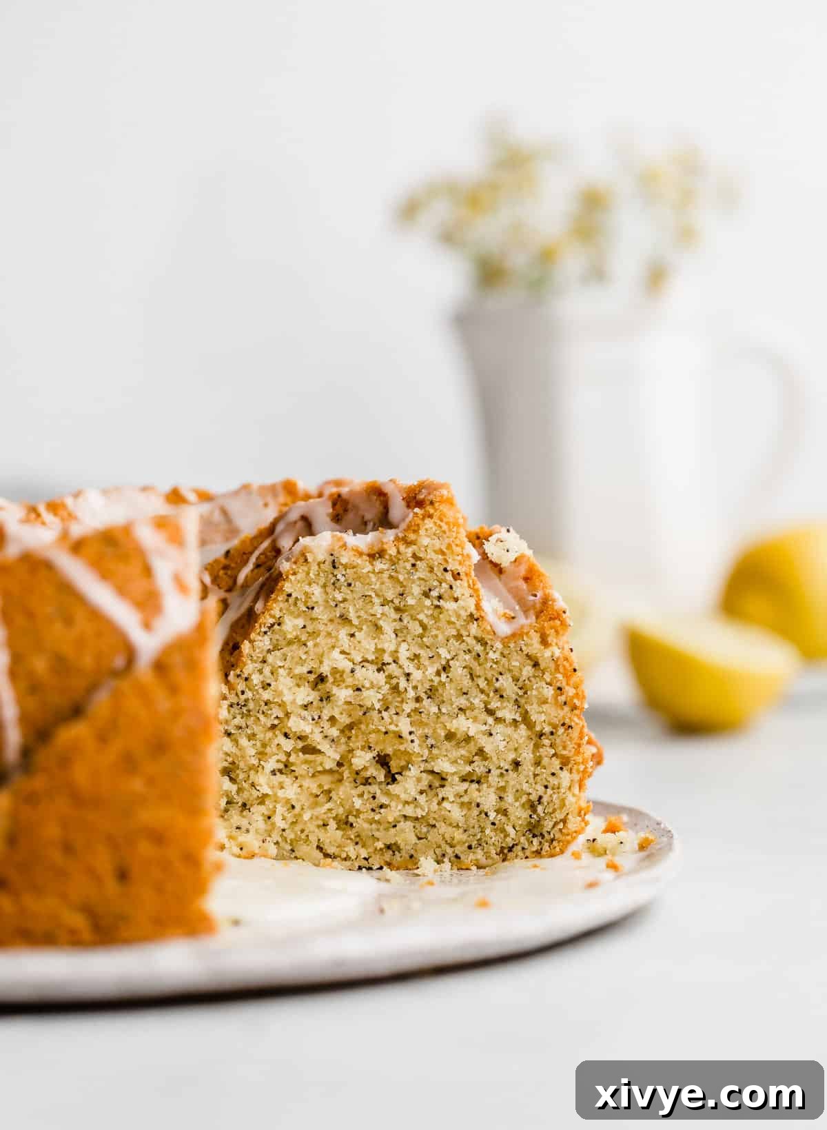 A beautiful Lemon Poppy Seed Bundt Cake against a clean white background, highlighting its texture and glaze.