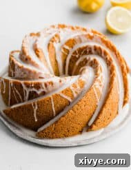 A Lemon Poppy Seed Bundt Cake topped with a white glaze on a white background.