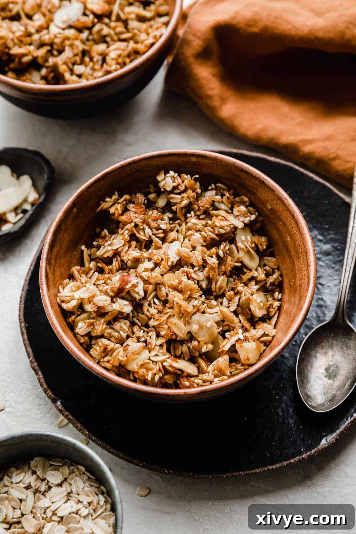 Granola cereal in brown bowl on a black plate.