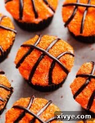 Basketball Cupcakes decorated with orange sprinkles and black licorice laces.