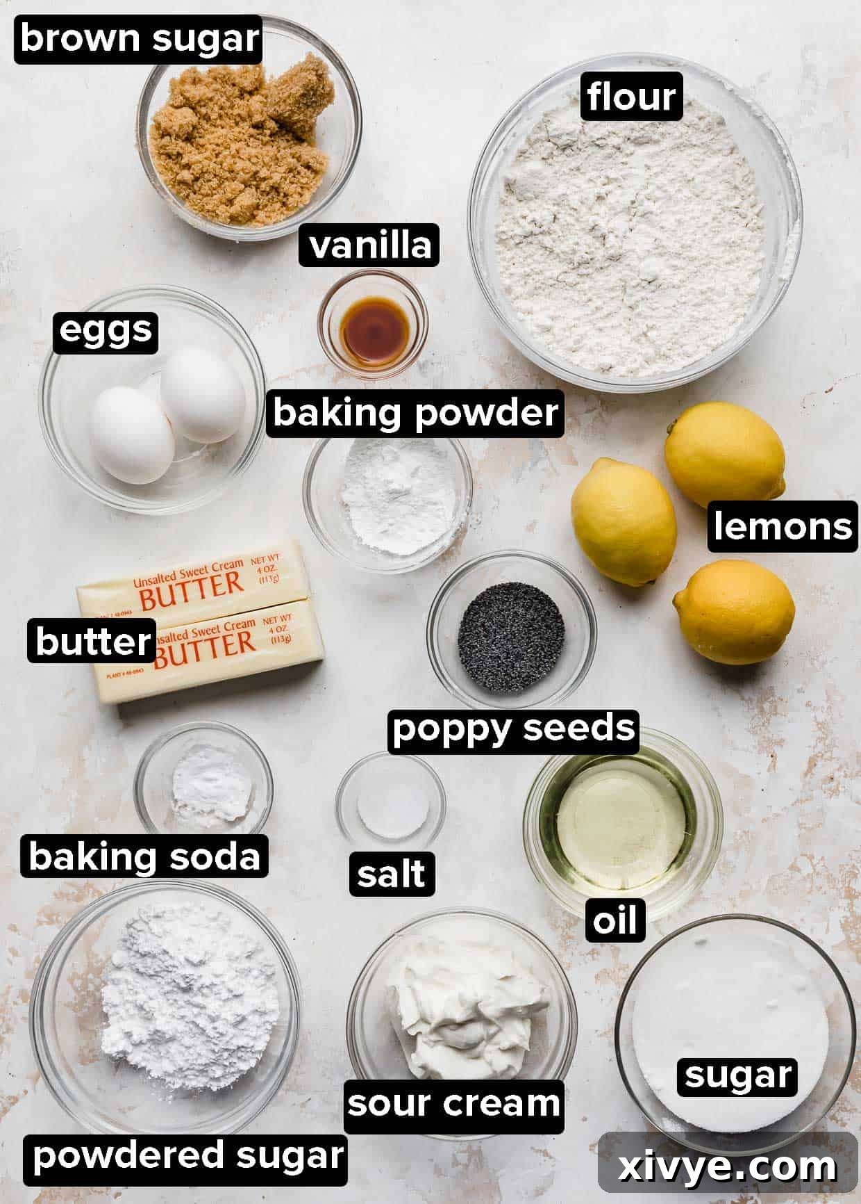 Zesty and Tender Lemon Poppy Seed Muffins 3 Lemon Poppy Seed Muffin ingredients portioned into glass bowls on a white textured background.