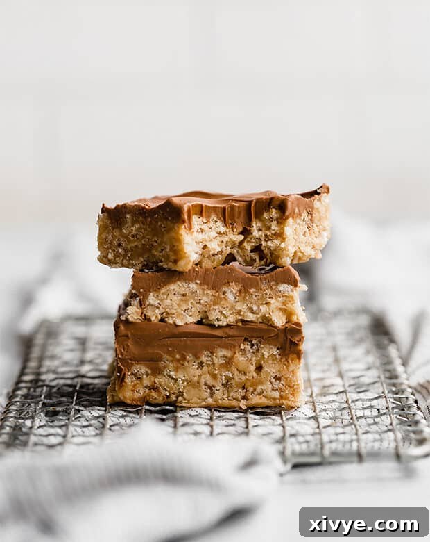 Three Scotcharoos stacked neatly, showcasing their thick, delicious layers and inviting topping.