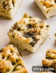 Herb topped fluffy Focaccia Bread cut into squares.