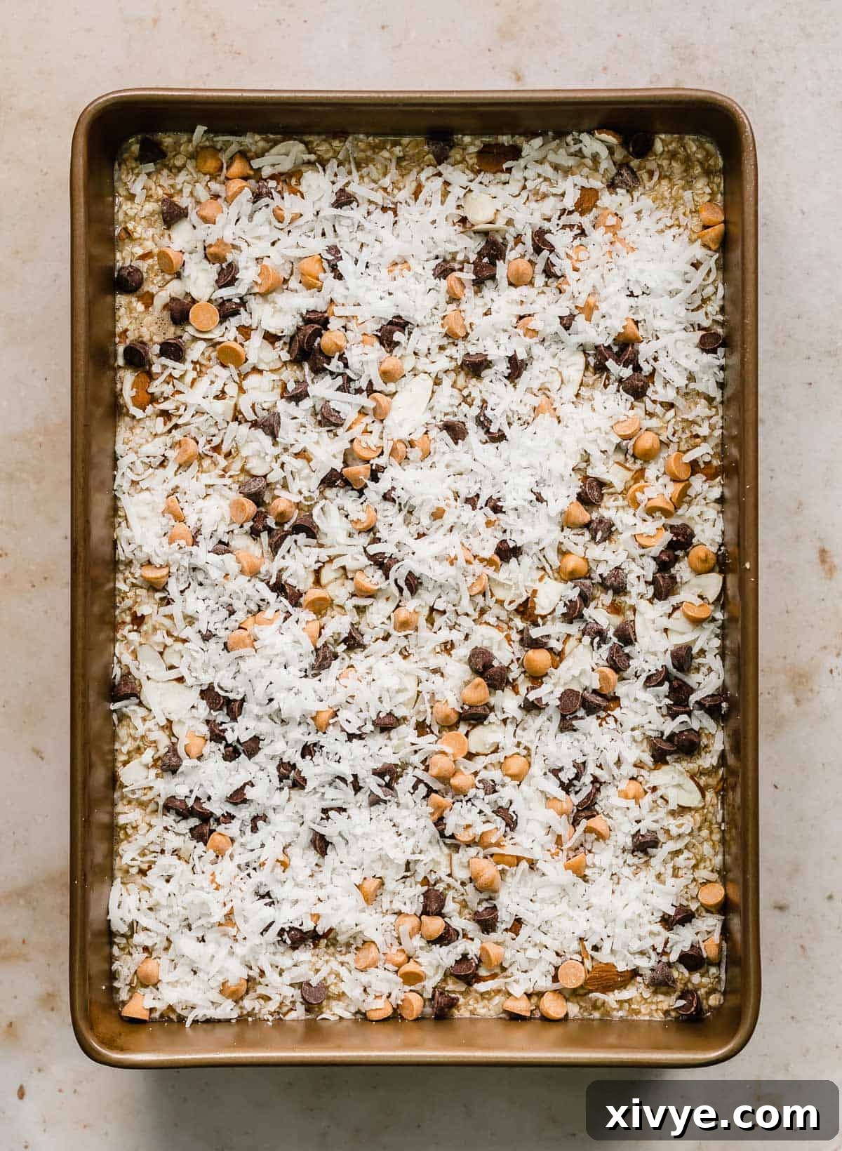 Breakfast Baked Oatmeal Cake topped with coconut, butterscotch and chocolate chips, cooling after baking.