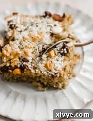 Baked Oatmeal Cake topped with coconut, butterscotch chips, chocolate chips, and hemp hearts, enticingly presented.