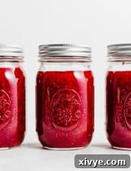 Three jars of Raspberry Freezer Jam against a white background.