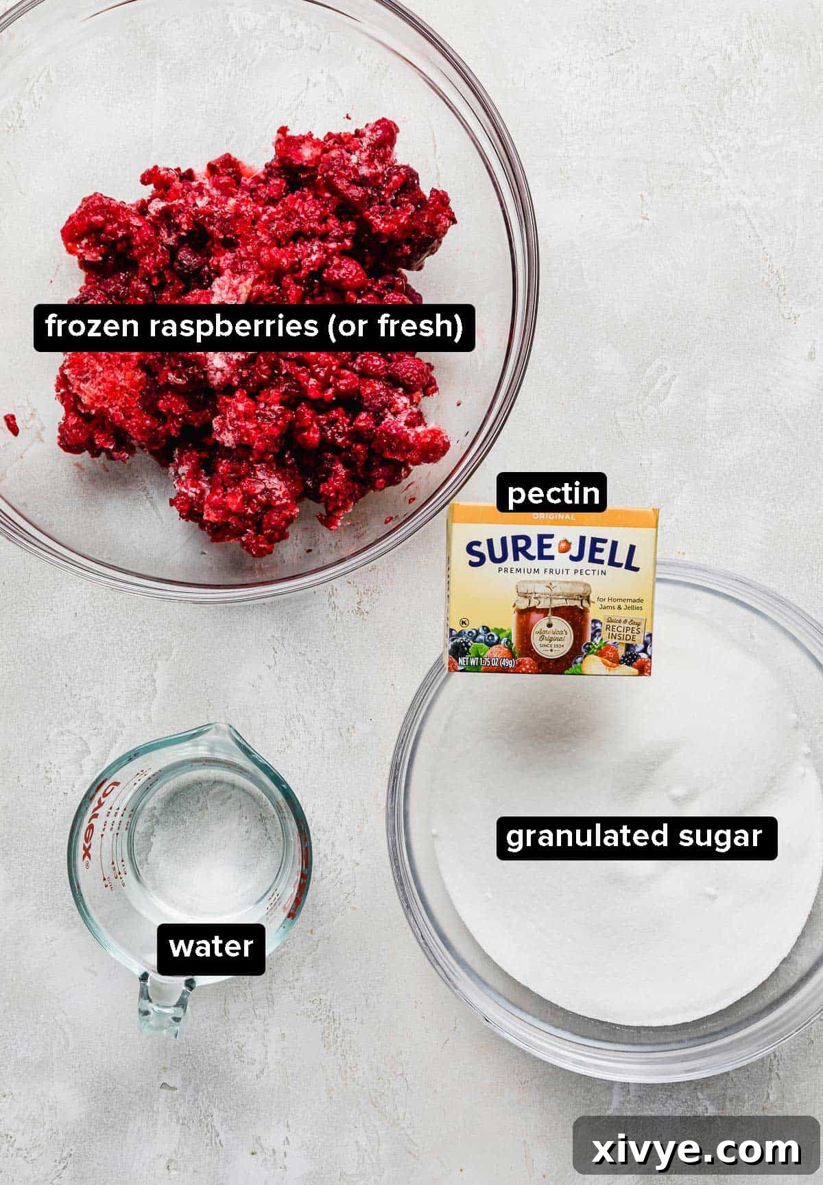 No-Fuss Raspberry Freezer Jam 3 Raspberry Freezer Jam ingredients on a white textured background.