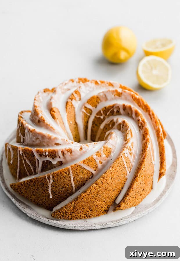 A beautifully glazed Lemon Poppy Seed Bundt Cake against a clean white background, inviting a taste of its citrusy freshness.