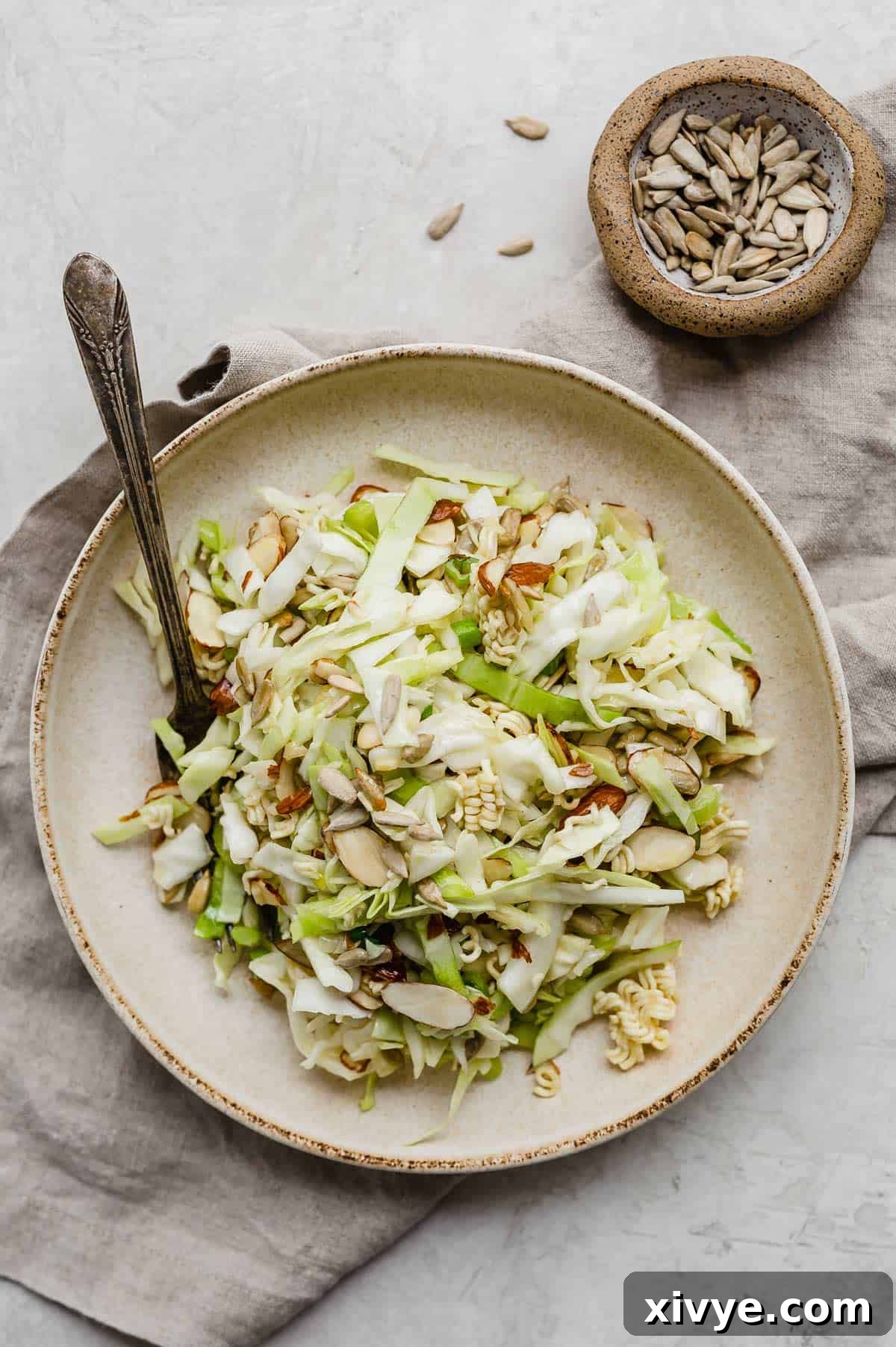 Crunchy Cabbage Salad in a tan pasta bowl on a gray background.