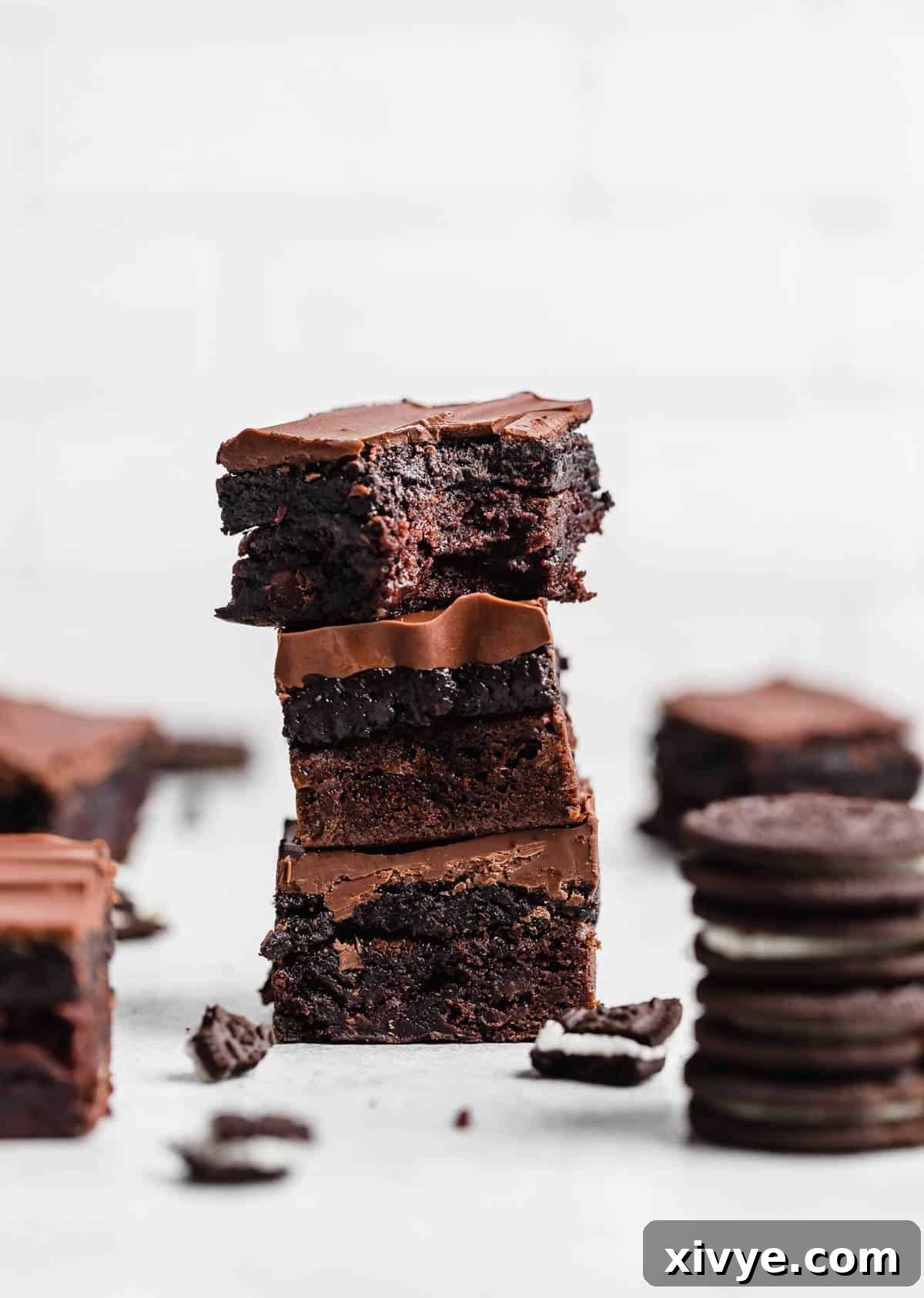 Decadent Oreo Truffle Brownies 6 Three Oreo Truffle Brownies stacked on top of each other against a white background.
