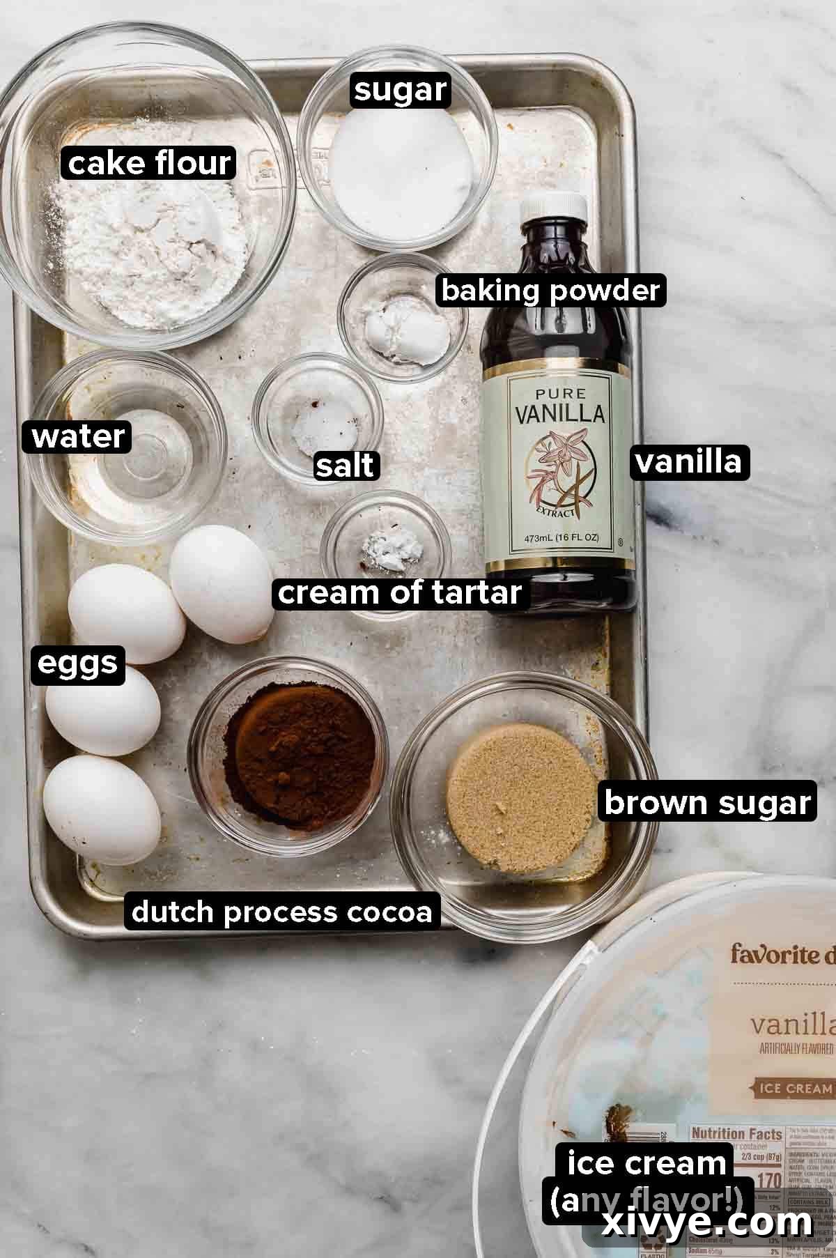 Ingredients for an Ice Cream Cake Roll arranged on a silver baking sheet against a clean white background.