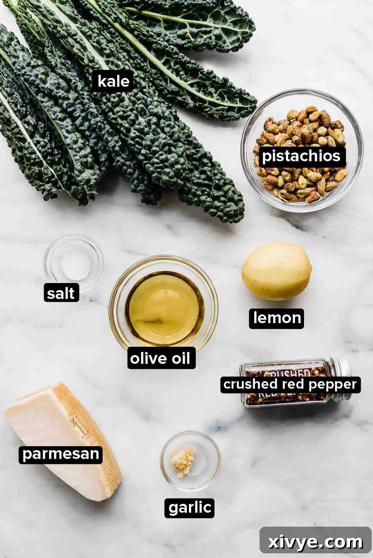 Healthy Homemade Kale Pesto 3 Kale Pesto ingredients on white background: kale, olive oil, pistachios, garlic, parmesan.