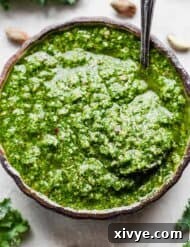 A bright green Kale Pesto made with pistachios and kale in a bowl.