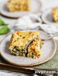 A fork cutting into a slice of breakfast casserole.