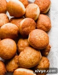 Freshly fried doughnuts on a tray.
