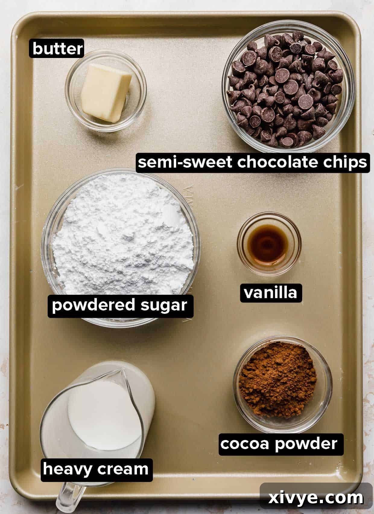 Perfect Homemade Boston Cream Donuts 4 Ingredients used to make the chocolate coating on a Boston Cream Donut, the ingredients portioned into glass bowls that are on a bronze baking sheet.