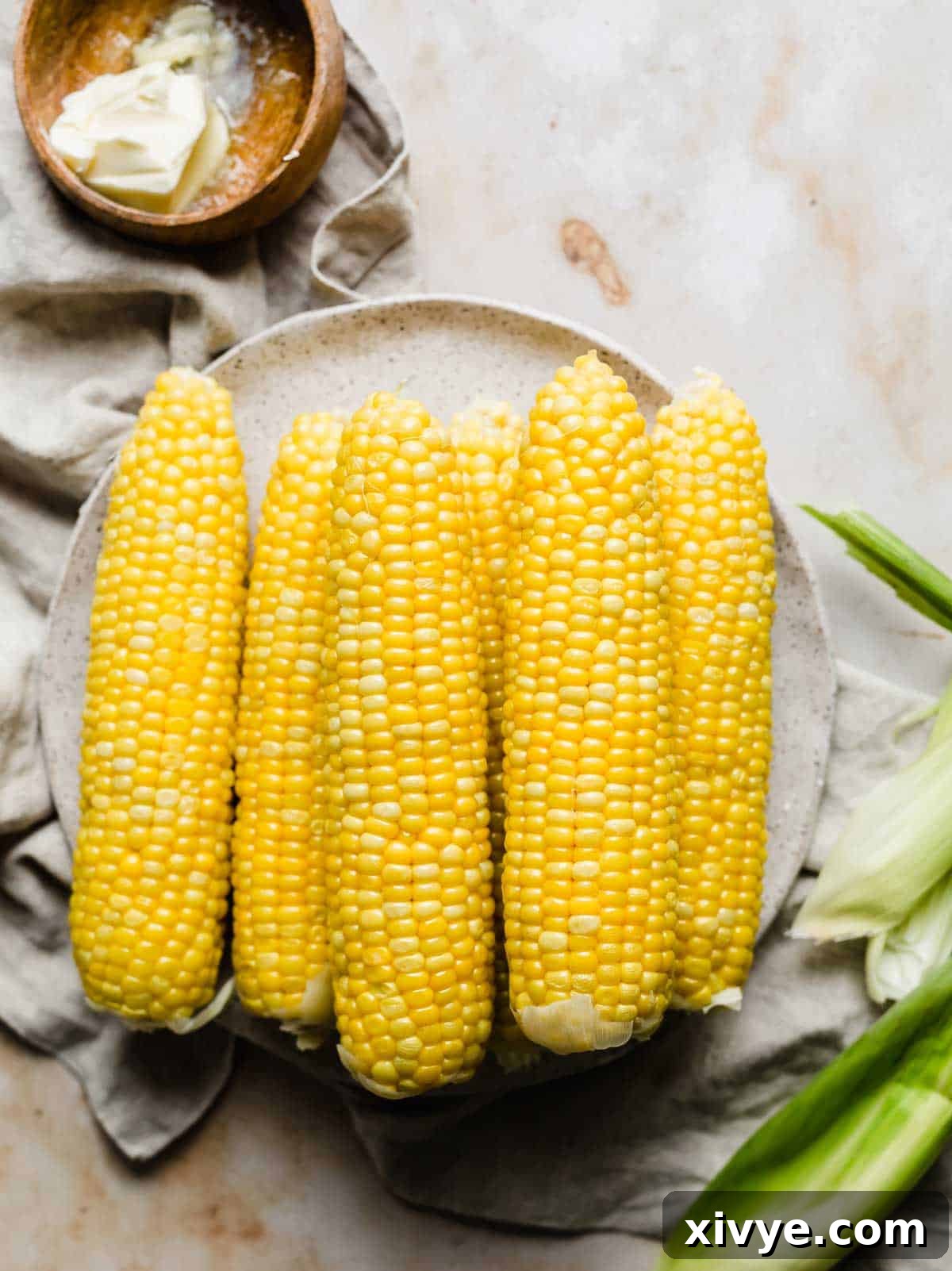 How to boil corn perfectly, showing six cooked corns on a plate.