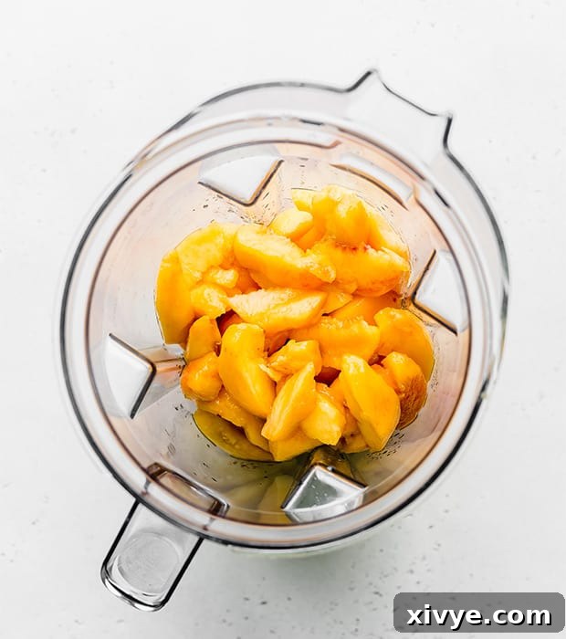 Overhead photo of freshly sliced peaches in a blender, ready for pureeing.