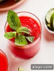 Watermelon Juice in a glass cup with a mint leaf for garnish.