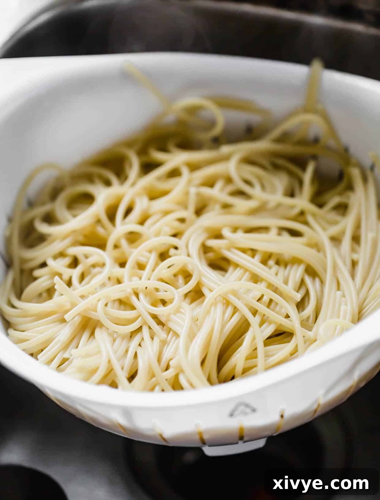 Savory Sesame Noodles 4 Spaghetti noodles in a white strainer.