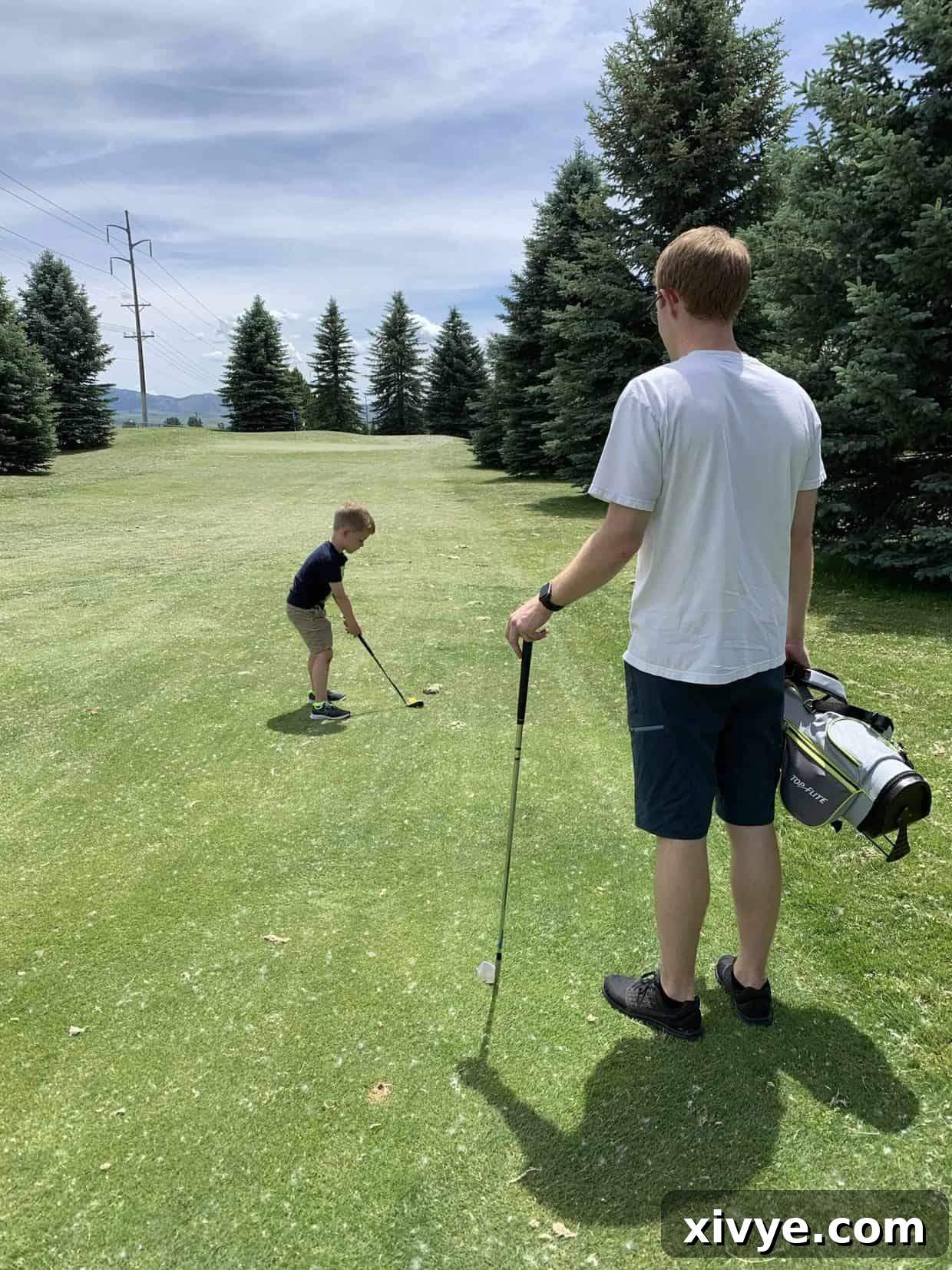 Midweek Delight 3 A young boy in a hat enthusiastically swinging a golf club on a green course.