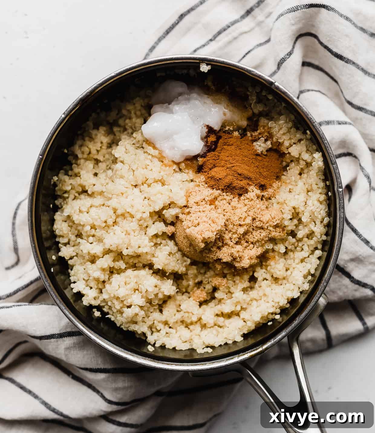 Wholesome Quinoa Porridge 6 A small pot with cooked quinoa, ground cinnamon, and brown sugar.