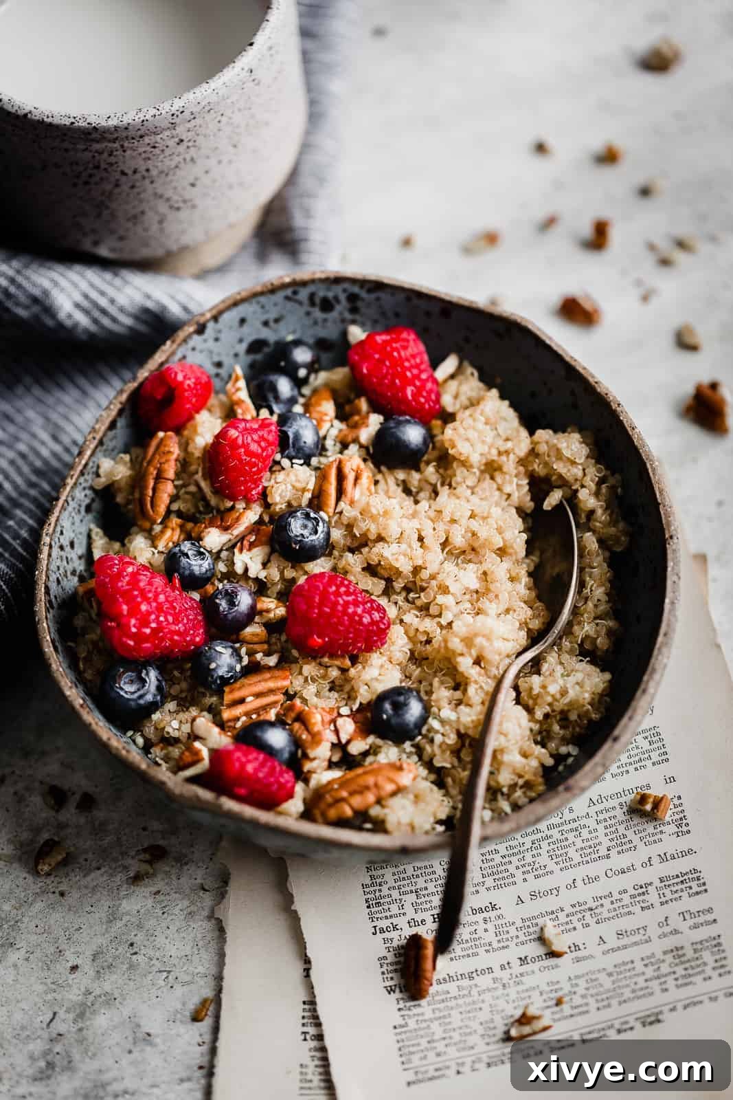 Wholesome Quinoa Porridge 7 A bowl of quinoa topped with fresh raspberries and blueberries.