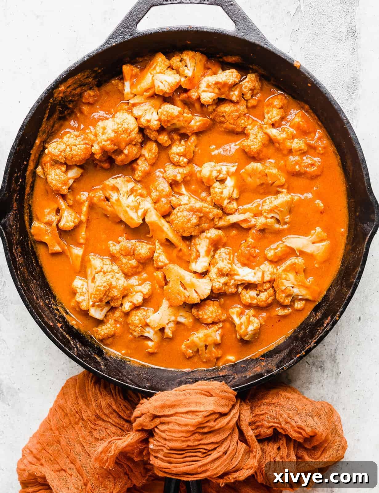 A black skillet full of orange colored Indian Butter Cauliflower.