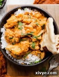 Indian Butter Cauliflower in a black bowl on a wooden background.