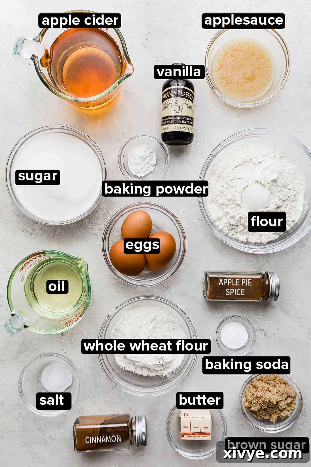 Apple Cider Bundt Cake ingredients portioned into glass bowls on a light gray background.
