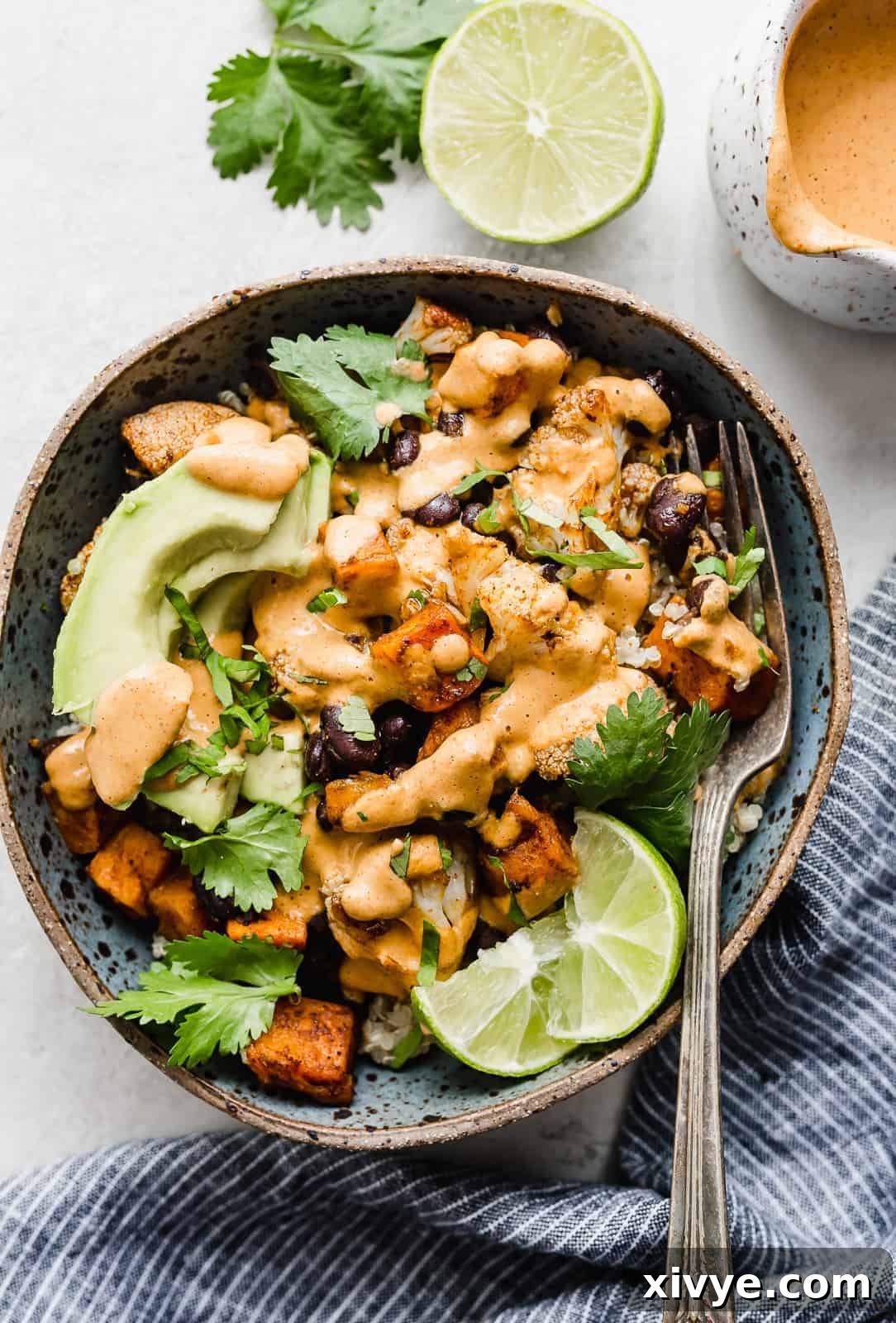 An inviting overhead shot of a single bowl filled with roasted sweet potato, cauliflower, and black beans, showcasing its rich textures and colors.