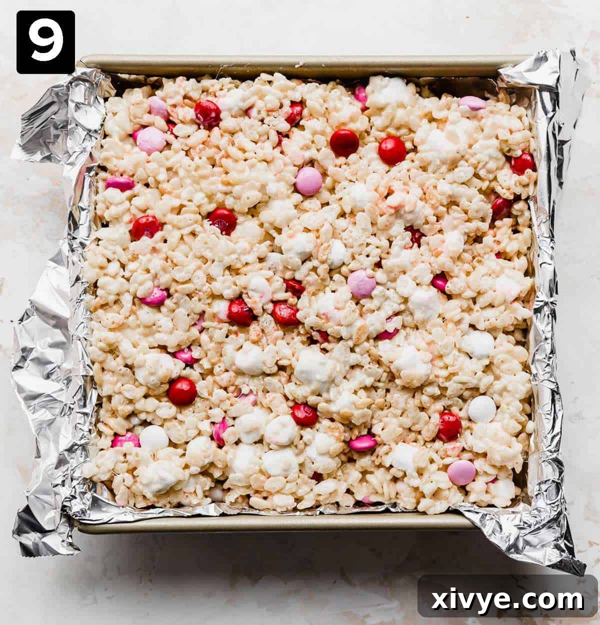 Colorful M&M Crispy Bars 6 A square pan with M&M Rice Krispie treats lightly pressed into it, ready to set.