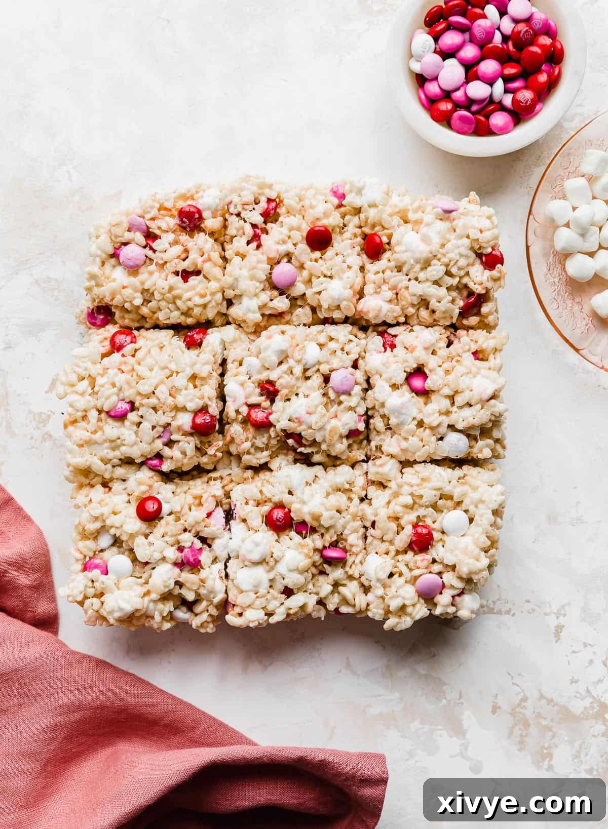 Colorful M&M Crispy Bars 7 Valentine Rice Krispie Treats cut into 9 squares on a white background, perfectly portioned.
