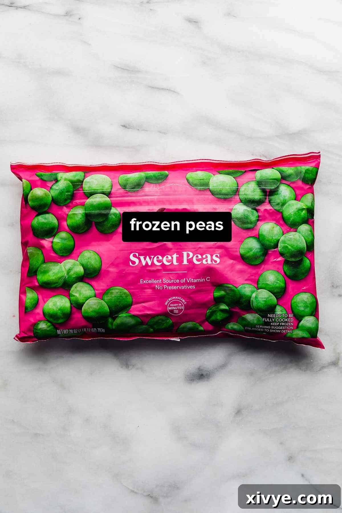 Elevate Your Frozen Peas 3 A sealed bag of frozen peas rests on a pristine white marble background, indicating the primary ingredient for cooking frozen peas.