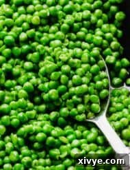 Elevate Your Frozen Peas 7 A silver serving spoon scooping up properly cooked frozen peas from a skillet, highlighting the delicious outcome of the sautéing method.