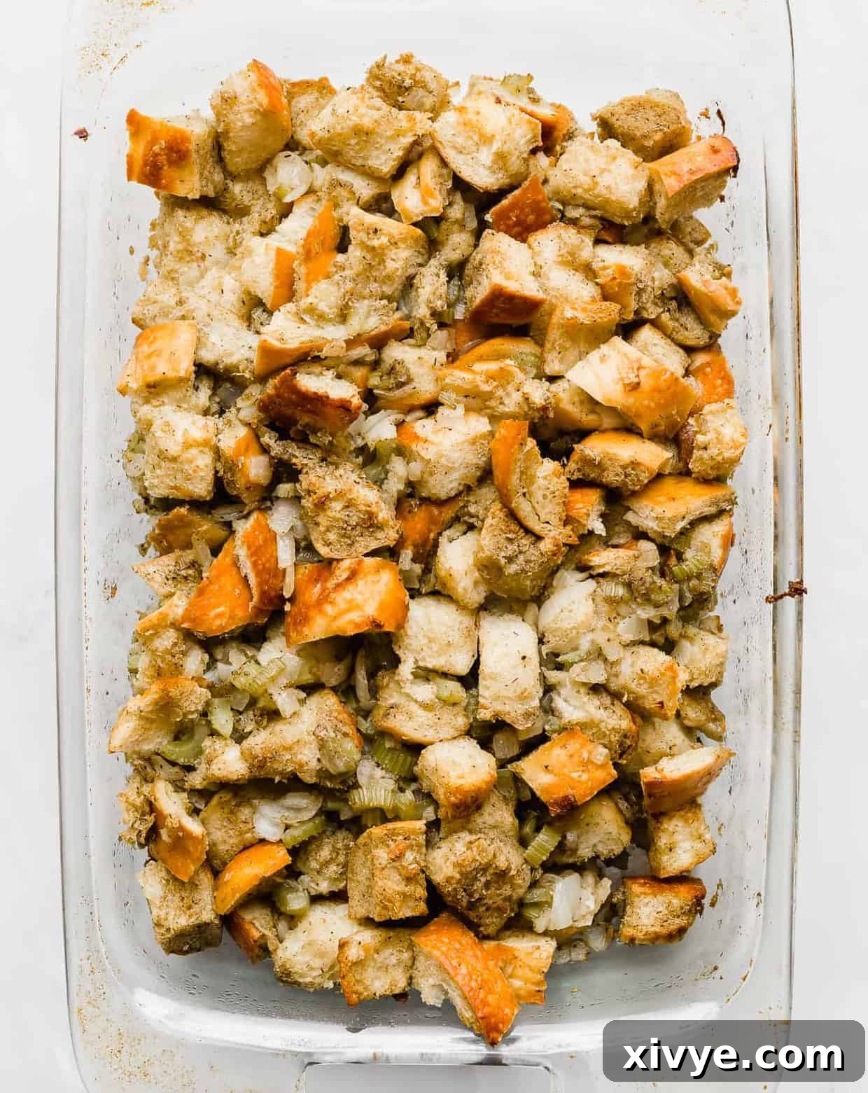 The Ultimate Thanksgiving Stuffing 8 Golden brown thanksgiving stuffing in a 13x9 inch clear baking dish.