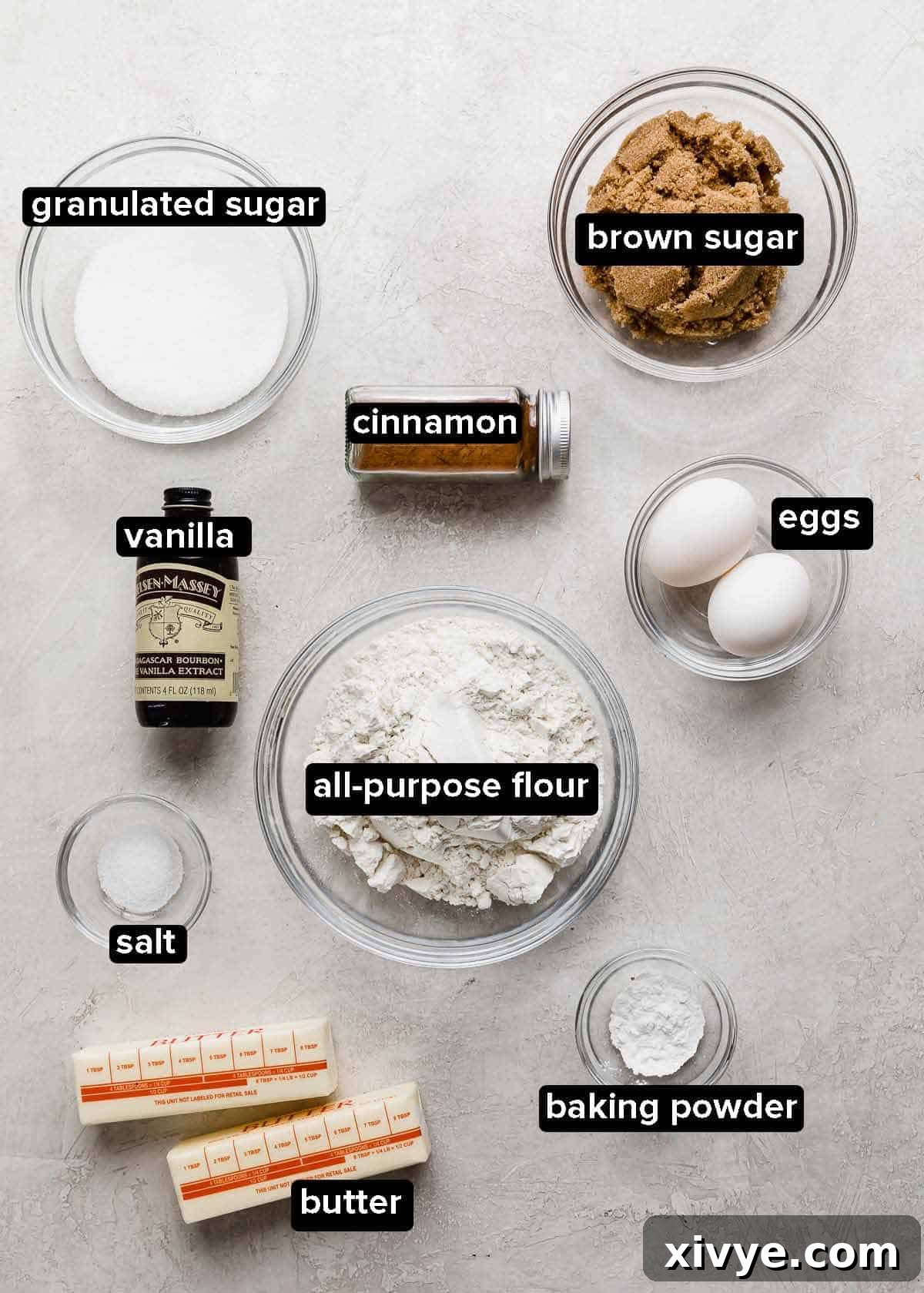 Cinnamon Roll Cookie ingredients portioned into glass bowls on a light gray background.