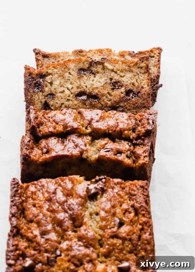 A beautifully sliced loaf of Chocolate Chip Banana Bread, revealing its tender crumb and abundant chocolate chips, ready to be served.